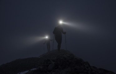 Two climbers and light beams on ridge