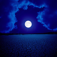 supermoon in clouds over desert
