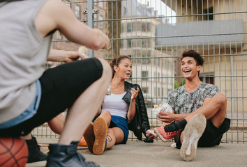 Group of friends hanging out on basketball court