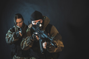 Man and woman in the images of a members of the special forces division with assault rifle in blue light. Russian police special force - Special Rapid Response Unit or SOBR (Spetsnaz).