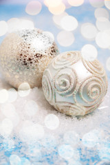 2 silberne Weihnachtskugel im glitzerndem Schnee