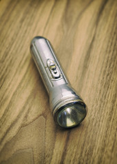 Retro Vintage Steel Flashlight on Wooden Surface