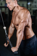 Fototapeta na wymiar Handsome muscular bodybuilder man doing exercises in gym