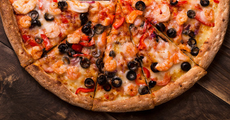 Pizza with seafood view from above on a wooden table