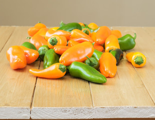 Multi-colored paprika on a wooden table.