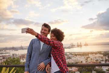 Young couple on bridge taking selfie