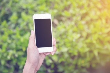 Women hand holding using mobile smart phone in the park