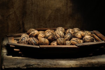 walnut in shell on  wooden platter, low key