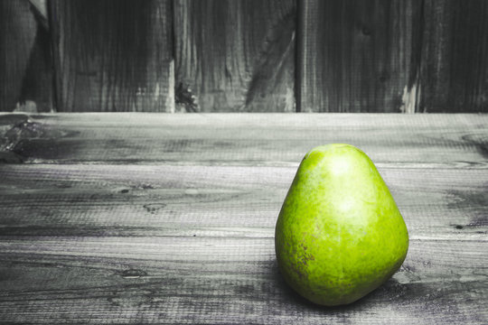 Green pear on grunge gray wooden table.
