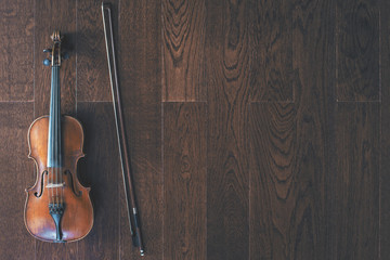 Violin with bow on wooden floor