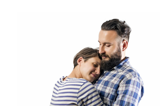 Portrait of a bearded guy who hugs a girl (wife, girlfriend). The image symbolizes: care, tenderness, love, allegiance, protection ... There is a spase for your text.