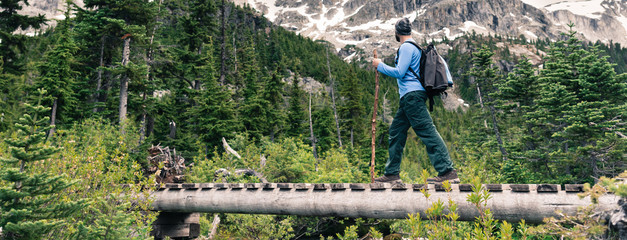 Active traveler crossing a bridge on a hiking trail