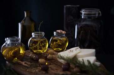 Obraz na płótnie Canvas Dark photography. Infused olive olive with spices and herbs: thyme, sage and pickled olives.
