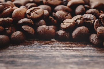 closeup coffee beans on wooden desk. vintage picture with place for your text