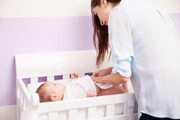 Woman changing a diaper for her baby