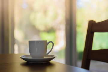 hot cup of black coffee in morning sunlight on a wooden table