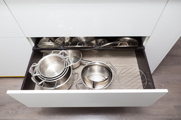 Opened drawer for pots and pans storage with special organizer for pan's lids 