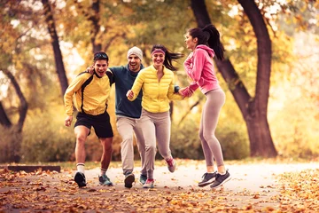 Foto auf Acrylglas Antireflex Junge Freunde, die im Park joggen. Herbstsaison. © BalanceFormCreative