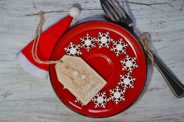 Christmas time table setting with silverware on red plate - festive table
