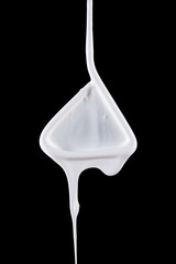 Flowing white paint drops on a black background