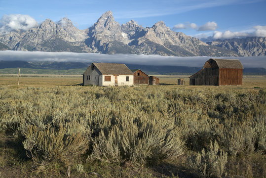 Scenic of Teton Mountain Range and historic buildings from the T.A. Moulton Ranch on Mormon Row in Grand Teton National Park, Jackson, Wyoming, North America