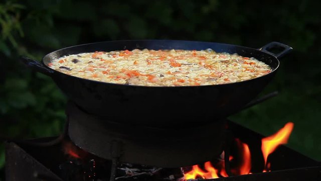 Plov (a.k.a. pilaf - traditional Middle Asian meal) is being prepared on the open fire in camp