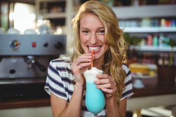 Portrait of woman drinking milkshake with a straw