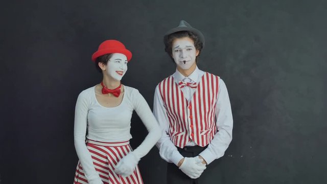 Two young mime laugh