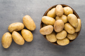New potato on the bowl, gray background.