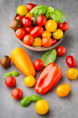 Tomatoes on the gray background. Colorful tomatoes, red tomatoes