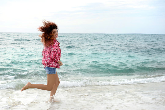 Beautiful Girl With Colorful Windbreaker Running On The Beach