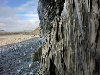 Layered vertical rock striations on beach shore