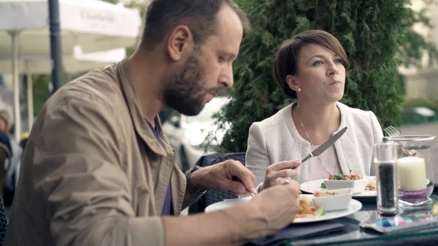 Young couple eating food in cafe, 4K 
