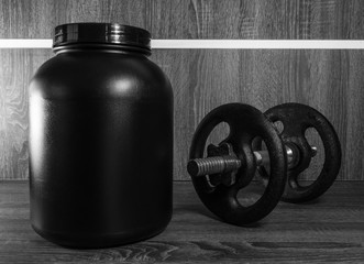 Fototapeta na wymiar Big pot of food supplement next to a barbell with gym weights.