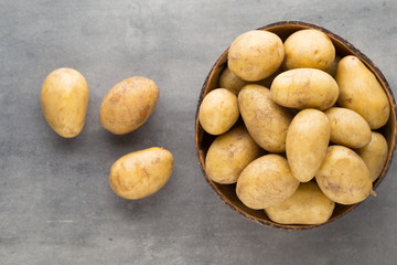 New potato on the bowl, gray background.