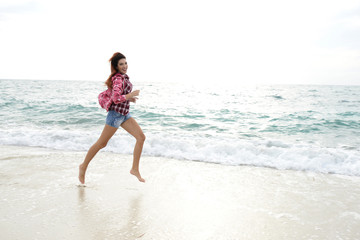 beautiful girl with colorful windbreaker running on the beach