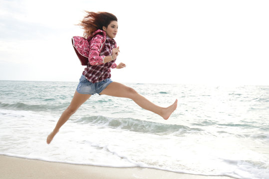 Beautiful Girl With Colorful Windbreaker Running On The Beach