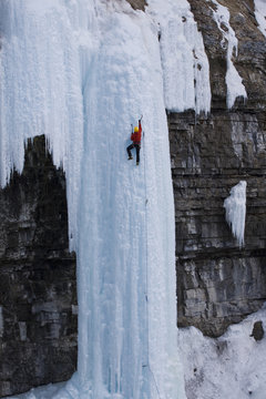 A male ice clmber tackles some steep ice in Johnstone  Canyon, Banff National Park, AB