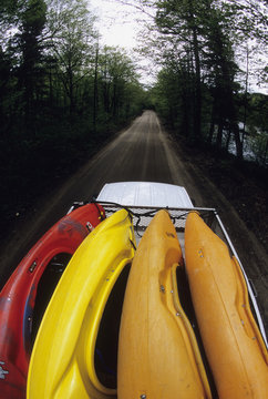 Van full of whitewater kayaks on backroad in Laurentien Mountains, Quebec, Canada.