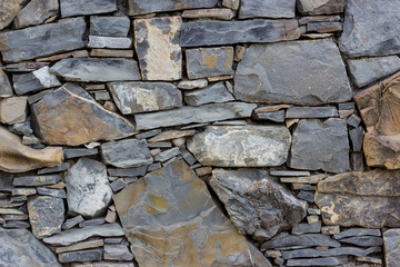 Fragment of the wall made of stones of different types and shapes