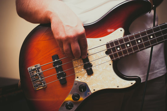 Detail of man playing bass instrument