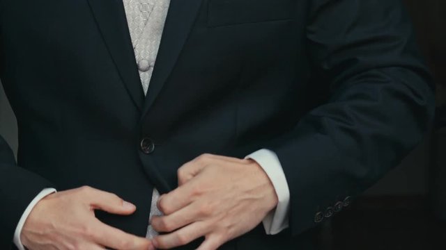 man buttoning on the jacket