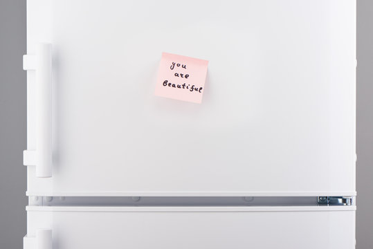 You are beautiful note on pink paper on white refrigerator