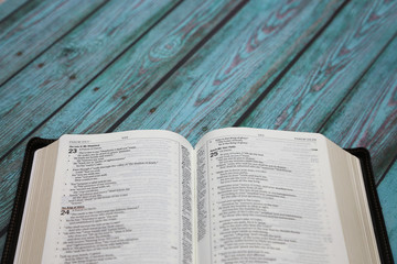 An Opened Bible on a Turquoise Distressed Wooden Table
