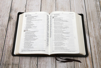An Opened Bible on a White Distressed Wooden Table