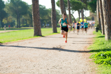 Fototapeta na wymiar runners in marathon in a park abstract, blurry 