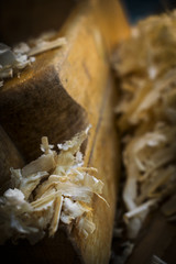 Pile of Sawdust in close-up view with piece of wood in dark environment 