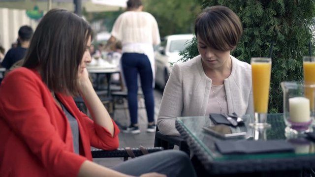 Two Beautiful Girlfriends Chatting In Cafe In The City, 4K 
