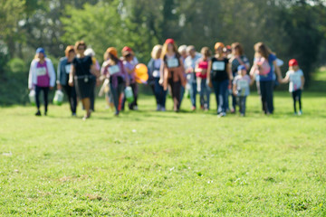 Obraz na płótnie Canvas line of unrecognizable people in a grass, blurry picture