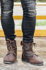 Men fashion, man's legs in black jeans and brown leather boots.